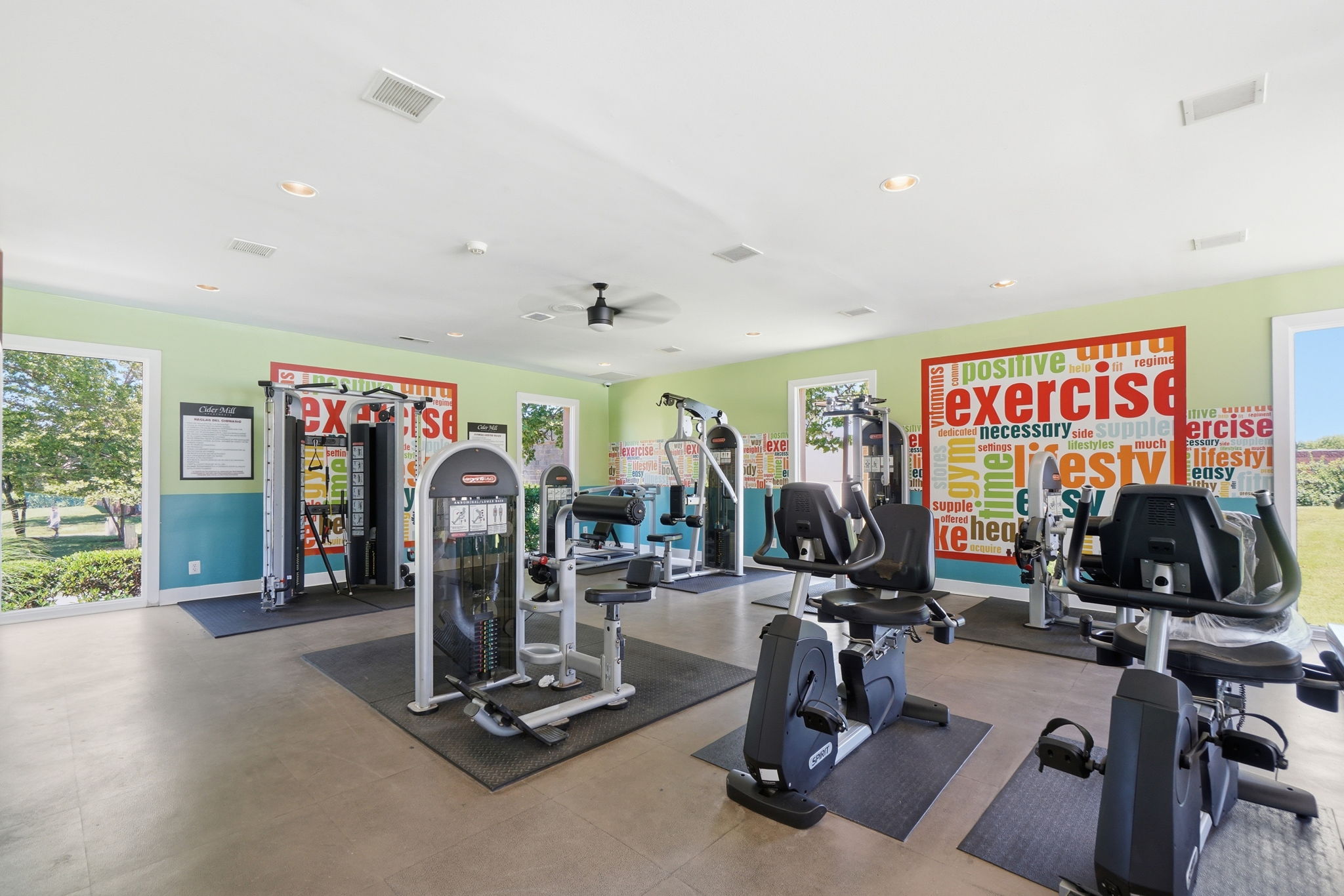 A gym with a variety of equipment including treadmills, weights, and exercise machines.